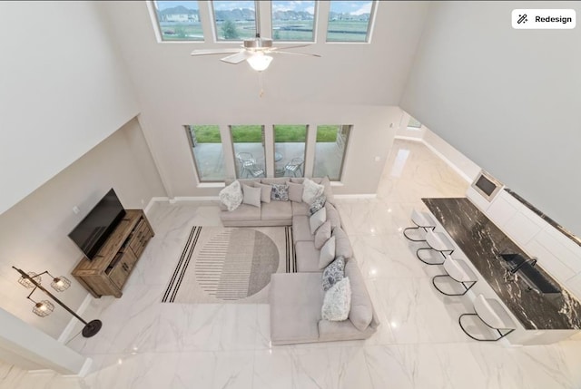8922 Granary Gate Ln, Richmond, TX 77407 - living room featuring marble finish floors, ceiling fan, and a towering ceiling