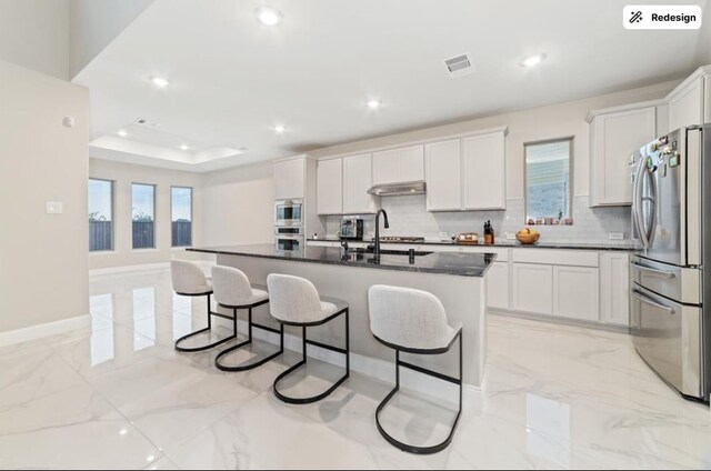 8922 Granary Gate Ln, Richmond, TX 77407 - kitchen with stainless steel appliances, backsplash, a breakfast bar area, light marble finish floors, and recessed lighting
