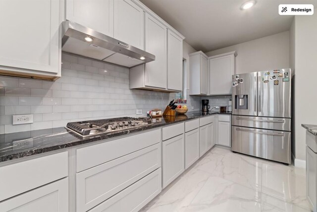 8922 Granary Gate Ln, Richmond, TX 77407 - kitchen with stainless steel appliances, range hood, light marble finish floors, backsplash, and dark stone countertops