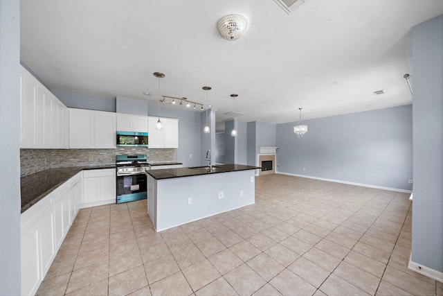 6306 Channelbrook Ln, Spring, TX 77379 - kitchen featuring appliances with stainless steel finishes, backsplash, light tile patterned floors, and dark countertops