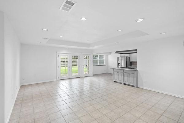 14419 Crosshaven Dr, Houston, TX 77015 - unfurnished living room featuring a tray ceiling, recessed lighting, french doors, and light tile patterned floors