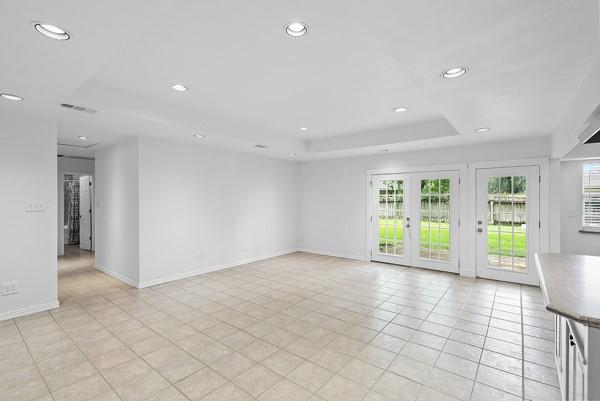 14419 Crosshaven Dr, Houston, TX 77015 - unfurnished living room with a tray ceiling, recessed lighting, and light tile patterned floors