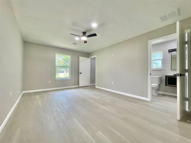 5039 Briscoe St, Houston, TX 77033 - unfurnished bedroom with light wood finished floors, multiple windows, connected bathroom, and ceiling fan