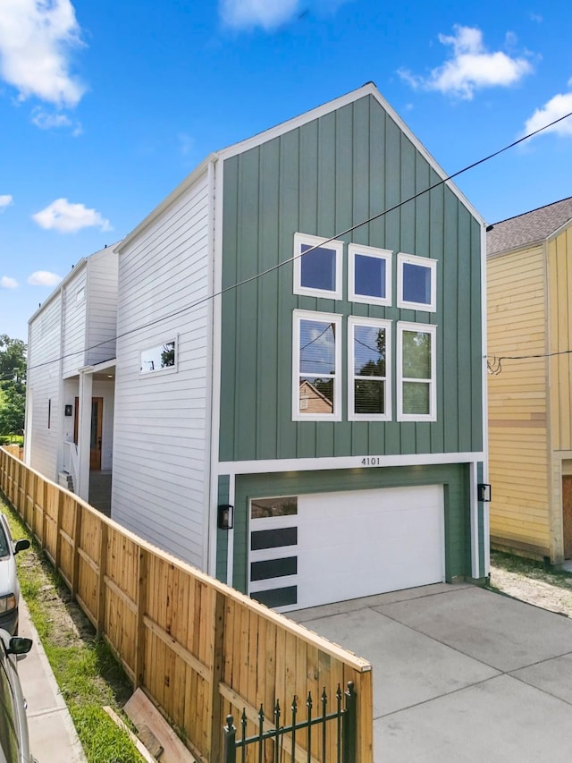4101 E Rogers St, Houston, TX 77022 - view of front facade featuring board and batten siding, an attached garage, and driveway