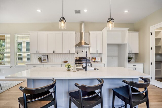 4101 E Rogers St, Houston, TX 77022 - kitchen with stainless steel range, wall chimney range hood, white cabinets, light countertops, and recessed lighting