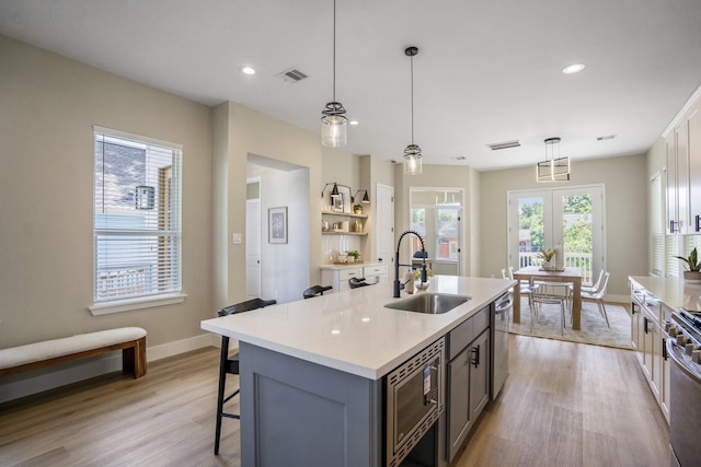 4101 E Rogers St, Houston, TX 77022 - kitchen with stainless steel appliances, light wood-type flooring, light countertops, a center island with sink, and a kitchen breakfast bar