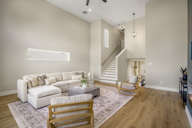 4101 E Rogers St, Houston, TX 77022 - living room featuring high vaulted ceiling, wood finished floors, stairway, and a ceiling fan
