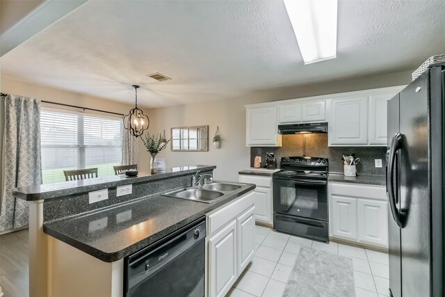9214 Stingray Ct, Texas City, TX 77591 - kitchen with black appliances, under cabinet range hood, dark countertops, white cabinetry, and an island with sink