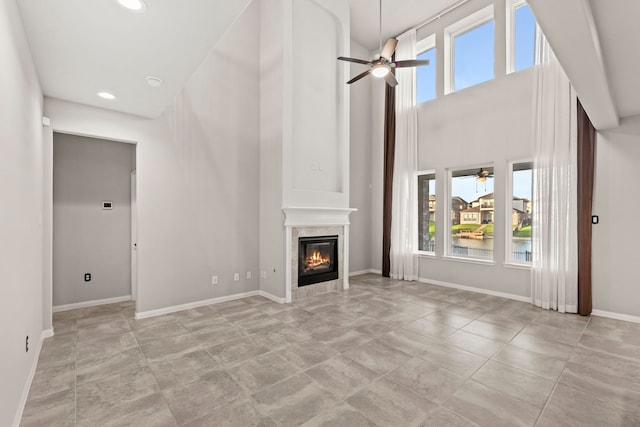 3506 Lake Bella Megan Dr, Katy, TX 77493 - unfurnished living room featuring ceiling fan, a tile fireplace, recessed lighting, and a towering ceiling