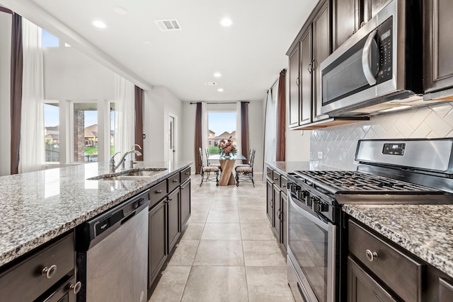 3506 Lake Bella Megan Dr, Katy, TX 77493 - kitchen with stainless steel appliances, backsplash, light stone counters, recessed lighting, and dark brown cabinets