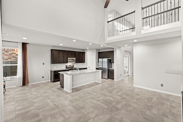 3506 Lake Bella Megan Dr, Katy, TX 77493 - kitchen with appliances with stainless steel finishes, a ceiling fan, a kitchen island with sink, dark brown cabinets, and recessed lighting