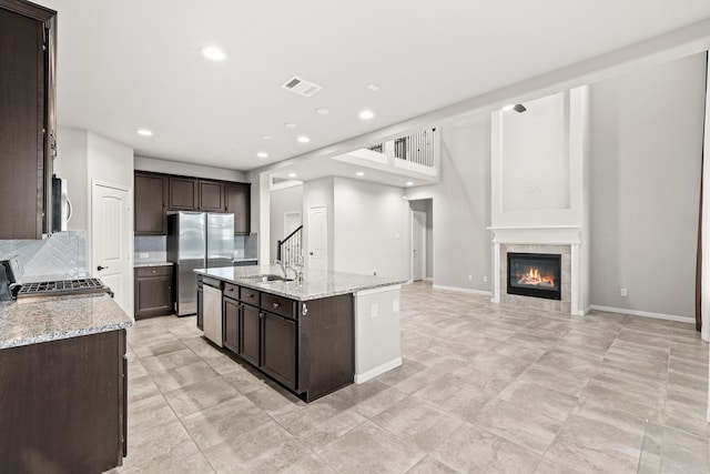 3506 Lake Bella Megan Dr, Katy, TX 77493 - kitchen featuring appliances with stainless steel finishes, dark brown cabinets, open floor plan, an island with sink, and recessed lighting