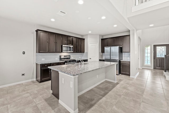 3506 Lake Bella Megan Dr, Katy, TX 77493 - kitchen featuring appliances with stainless steel finishes, decorative backsplash, recessed lighting, a kitchen island with sink, and dark brown cabinetry