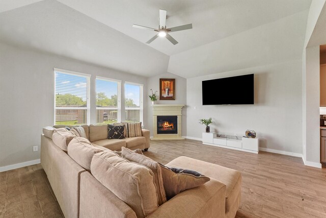 2231 Bright Sunrise Trl, Fresno, TX 77545 - living area with a glass covered fireplace, light wood-style flooring, ceiling fan, and vaulted ceiling