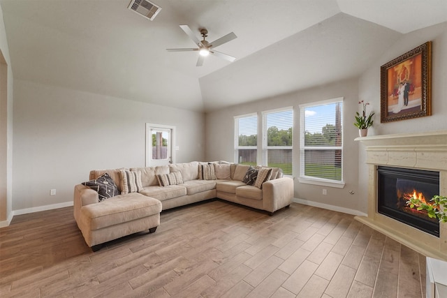 2231 Bright Sunrise Trl, Fresno, TX 77545 - living area with vaulted ceiling, light wood finished floors, a glass covered fireplace, and a ceiling fan