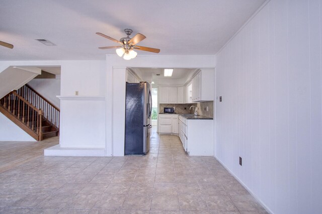 11667 Sabo Rd, Houston, TX 77089 - kitchen with freestanding refrigerator, a ceiling fan, dark countertops, and white cabinetry