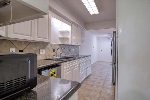 11667 Sabo Rd, Houston, TX 77089 - kitchen with white cabinetry, decorative backsplash, freestanding refrigerator, and light tile patterned flooring