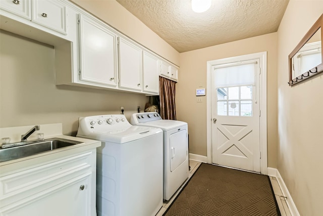 3914 Cherry Forest Dr, Houston, TX 77088 - laundry room featuring washer and dryer, cabinet space, a textured ceiling, and dark tile patterned flooring