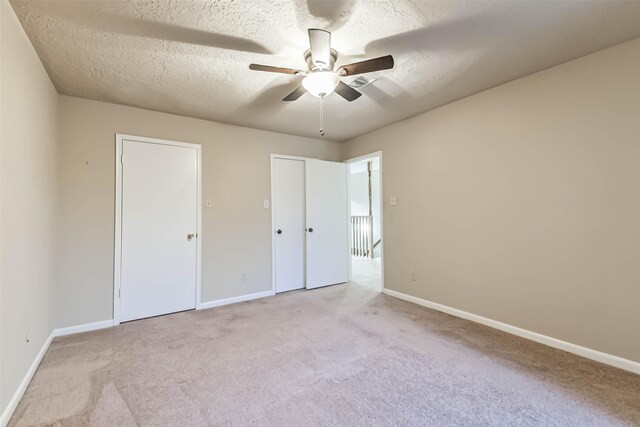 3914 Cherry Forest Dr, Houston, TX 77088 - unfurnished bedroom with carpet flooring, a textured ceiling, multiple closets, and ceiling fan