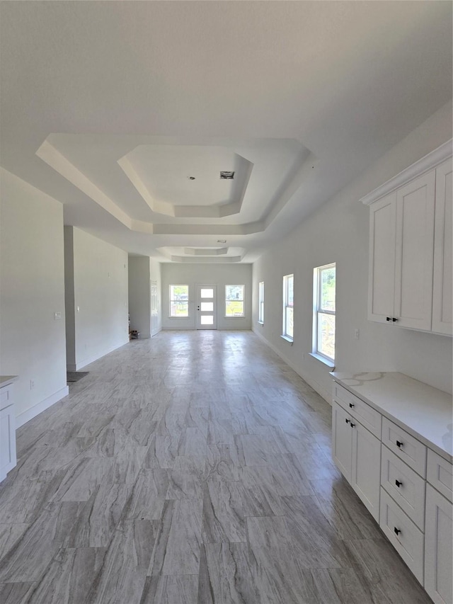 14387 Half Circle St, Splendora, TX 77372 - unfurnished living room with a tray ceiling and baseboards