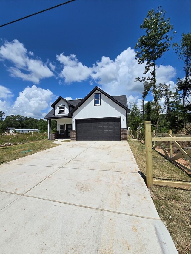 14387 Half Circle St, Splendora, TX 77372 - view of front facade featuring brick siding, driveway, and a garage