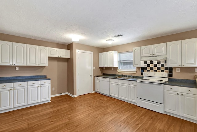 8910 E Buffalo Cir, Willis, TX 77378 - kitchen with white appliances, under cabinet range hood, white cabinets, dark countertops, and a textured ceiling
