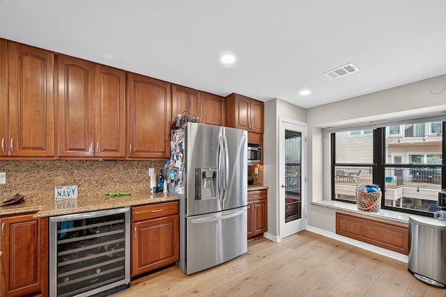 3663 Nasa Pkwy Unit 301, Seabrook, TX 77586 - kitchen featuring appliances with stainless steel finishes, beverage cooler, brown cabinetry, backsplash, and recessed lighting