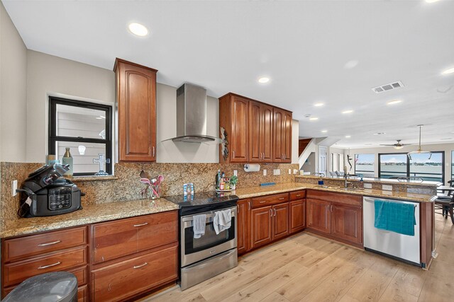 3663 Nasa Pkwy Unit 301, Seabrook, TX 77586 - kitchen featuring stainless steel appliances, wall chimney exhaust hood, light wood-type flooring, decorative backsplash, and recessed lighting