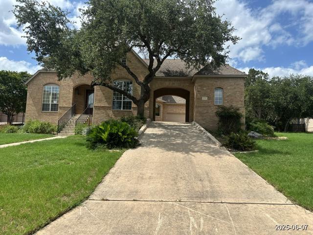 1715 Palmer Vw, San Antonio, TX 78260 - french country home featuring a front yard, driveway, and brick siding