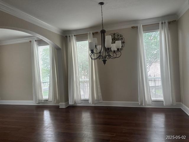 1715 Palmer Vw, San Antonio, TX 78260 - unfurnished dining area with a chandelier, hardwood / wood-style floors, crown molding, and arched walkways