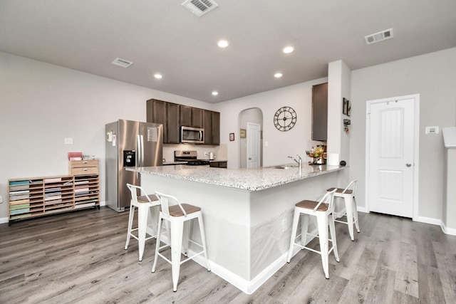 2832 Madison Dr, Conroe, TX 77304 - kitchen with stainless steel appliances, a kitchen bar, light wood finished floors, and recessed lighting