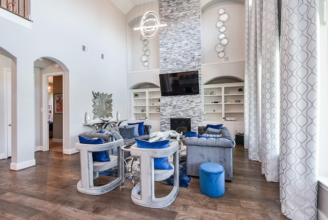 2510 Serene Path, Missouri City, TX 77459 - living room with wood finished floors, built in features, a high ceiling, a fireplace, and arched walkways
