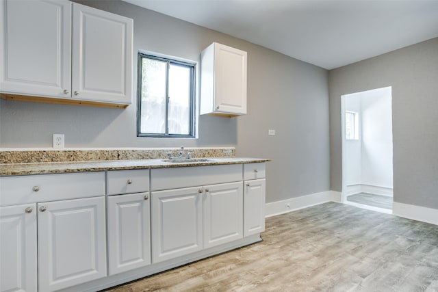 810-812 Maltby St Unit 6, Houston, TX 77011 - kitchen with light wood-style floors, white cabinetry, and light stone countertops
