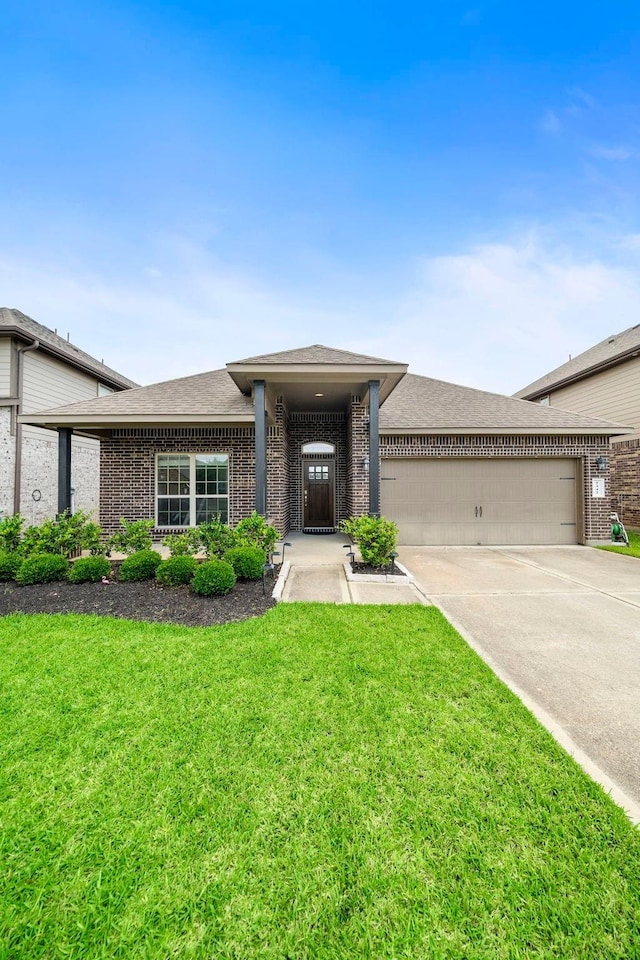 5442 Atwood Canyon Ct, Richmond, TX 77407 - view of front of home featuring an attached garage, concrete driveway, brick siding, a front lawn, and roof with shingles