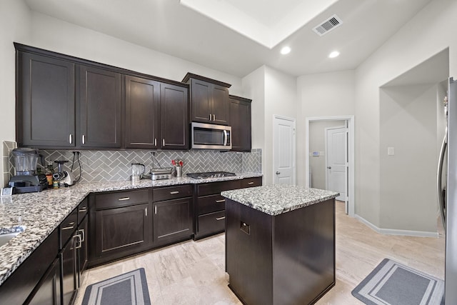5442 Atwood Canyon Ct, Richmond, TX 77407 - kitchen with stainless steel appliances, tasteful backsplash, dark brown cabinetry, light stone counters, and recessed lighting