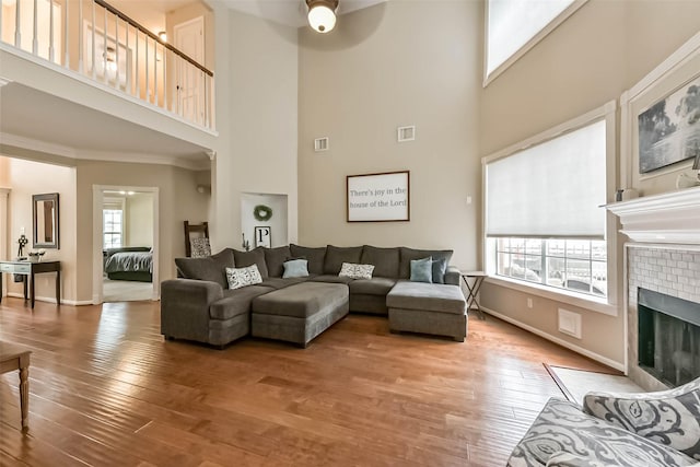 6402 Saint Jude Dr, Pasadena, TX 77505 - living area with a high ceiling, a ceiling fan, healthy amount of natural light, a fireplace, and wood finished floors