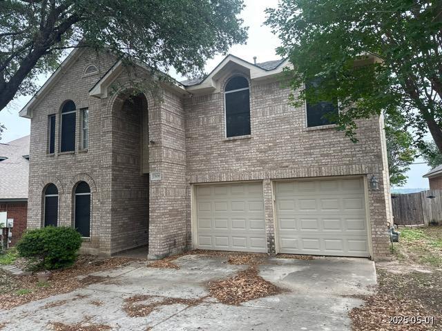 7306 Ellerby Pt, San Antonio, TX 78240 - view of front facade featuring an attached garage, concrete driveway, and brick siding