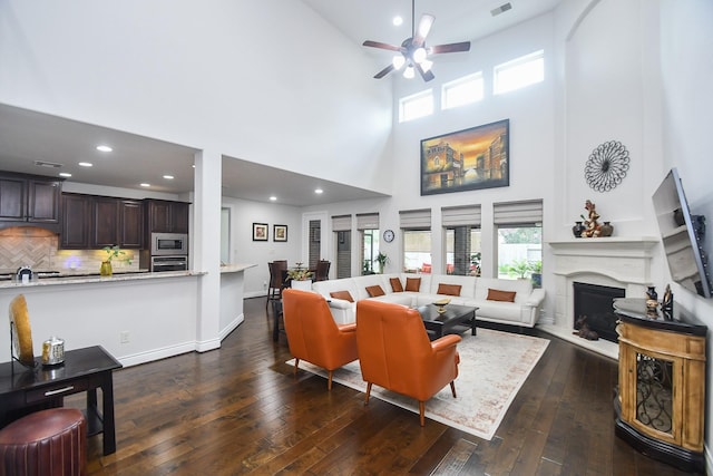 2710 Indigo Manor Ln, Katy, TX 77494 - living room with a high ceiling, a ceiling fan, dark wood-type flooring, a fireplace with raised hearth, and recessed lighting