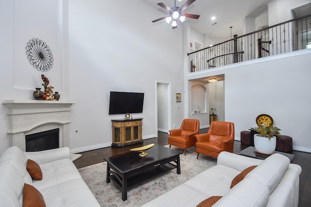 2710 Indigo Manor Ln, Katy, TX 77494 - living room featuring wood finished floors, ceiling fan, a high ceiling, and a glass covered fireplace