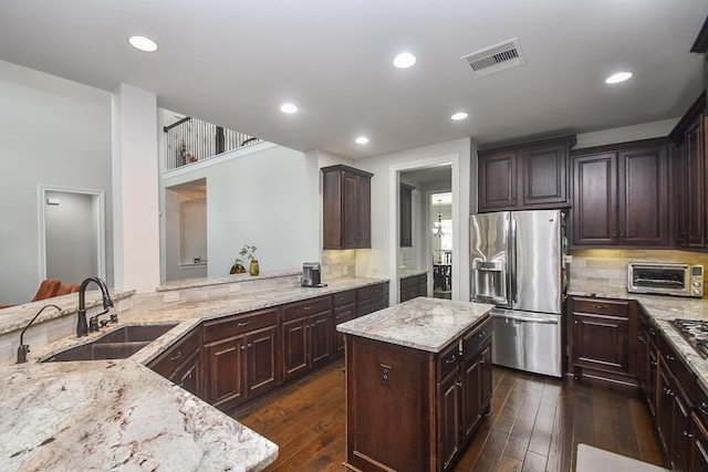 2710 Indigo Manor Ln, Katy, TX 77494 - kitchen with stainless steel fridge with ice dispenser, light stone counters, dark wood-style floors, backsplash, and dark brown cabinetry