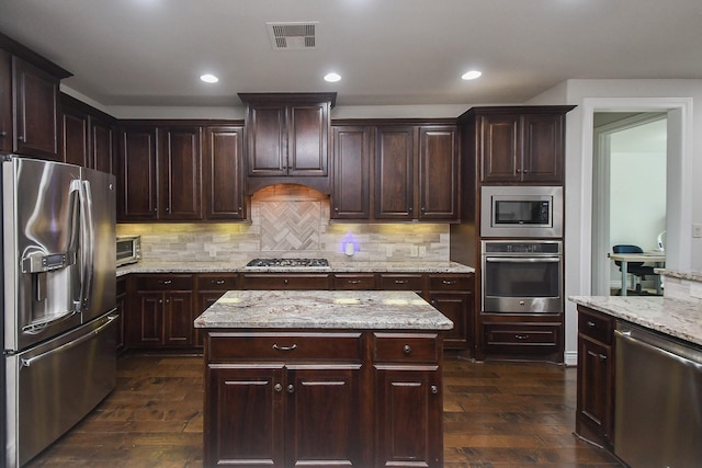 2710 Indigo Manor Ln, Katy, TX 77494 - kitchen with appliances with stainless steel finishes, dark wood finished floors, backsplash, dark brown cabinetry, and recessed lighting