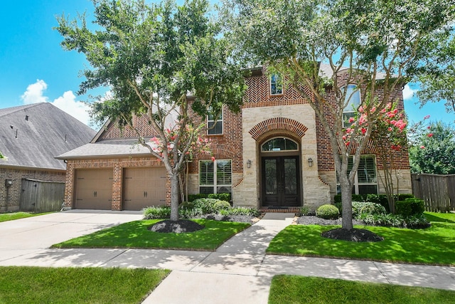 2710 Indigo Manor Ln, Katy, TX 77494 - view of front of house featuring french doors, brick siding, stone siding, a garage, and driveway