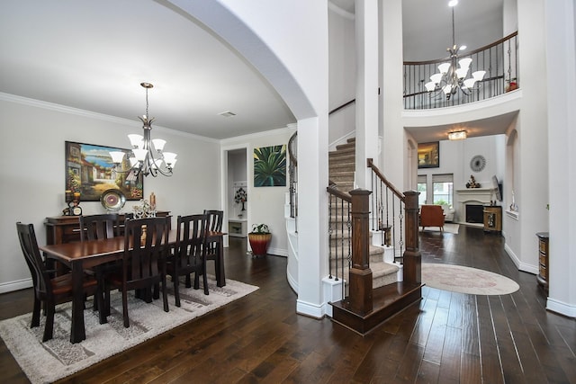 2710 Indigo Manor Ln, Katy, TX 77494 - dining room with a chandelier, arched walkways, hardwood / wood-style flooring, stairs, and crown molding