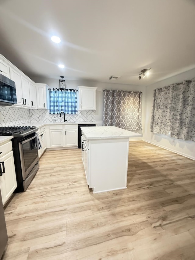 20918 Southhook Ct, Houston, TX 77073 - kitchen featuring stainless steel appliances, tasteful backsplash, a center island, white cabinets, and light wood-style floors