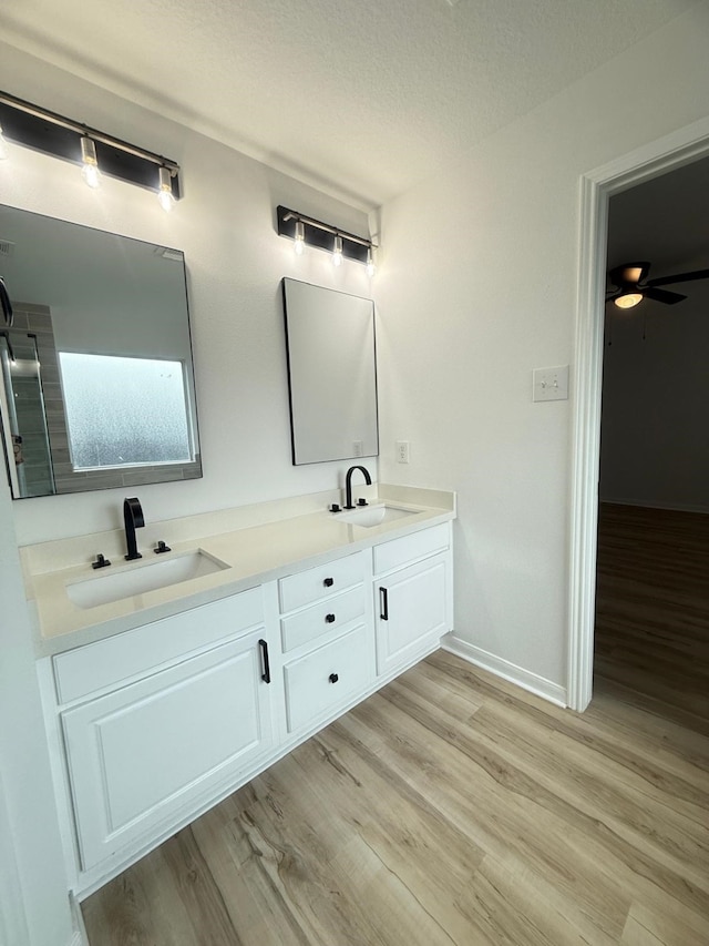 20918 Southhook Ct, Houston, TX 77073 - bathroom with wood finished floors, double vanity, a textured ceiling, and a ceiling fan