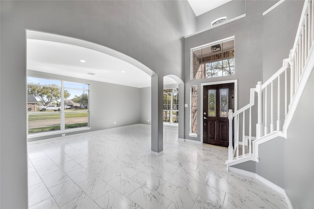 537 Green Cedar Dr, League City, TX 77573 - entrance foyer with arched walkways, healthy amount of natural light, stairway, marble look tile flooring, and a towering ceiling