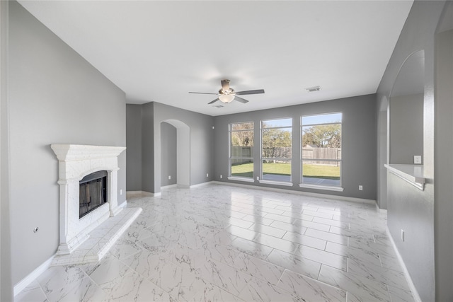 537 Green Cedar Dr, League City, TX 77573 - unfurnished living room featuring arched walkways, ceiling fan, light marble finish floors, and a fireplace with raised hearth