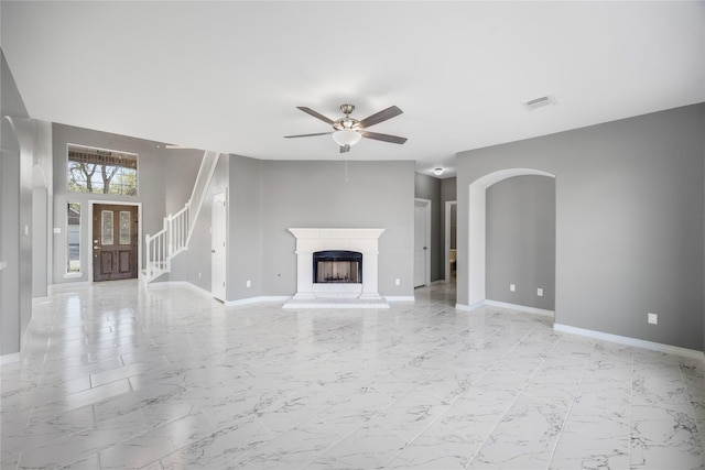 537 Green Cedar Dr, League City, TX 77573 - unfurnished living room with light marble finish flooring, a ceiling fan, a fireplace with raised hearth, and stairway