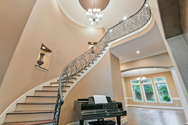 13622 Kluge Corner Ln, Cypress, TX 77429 - stairs featuring a chandelier, ornamental molding, a high ceiling, ornate columns, and wood finished floors