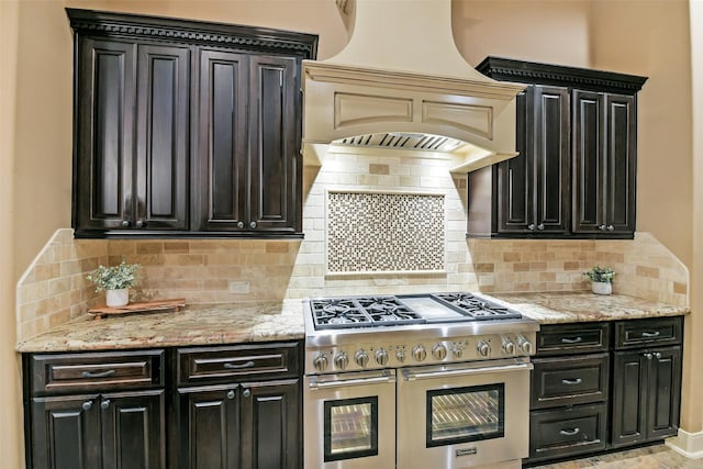 13622 Kluge Corner Ln, Cypress, TX 77429 - kitchen with double oven range, tasteful backsplash, dark cabinetry, and custom range hood